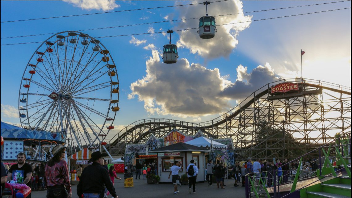 The Washington State Fair midway at sunset: the Ferris wheel, the SkyRide gondolas, and the wooden Classic Coaster