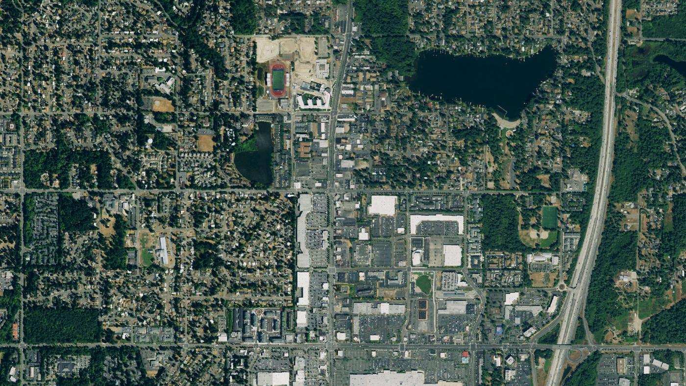 Downtown Federal Way from above: Steel Lake at top right, I-5 along the right edge, Pacific Highway South and the Federal Way Memorial Field track at upper left, and The Commons mall at the bottom