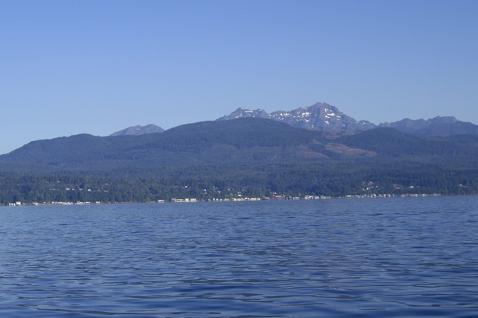 Waterfront homes strung along the Hood Canal shoreline at Belfair, the Olympic Mountains rising behind