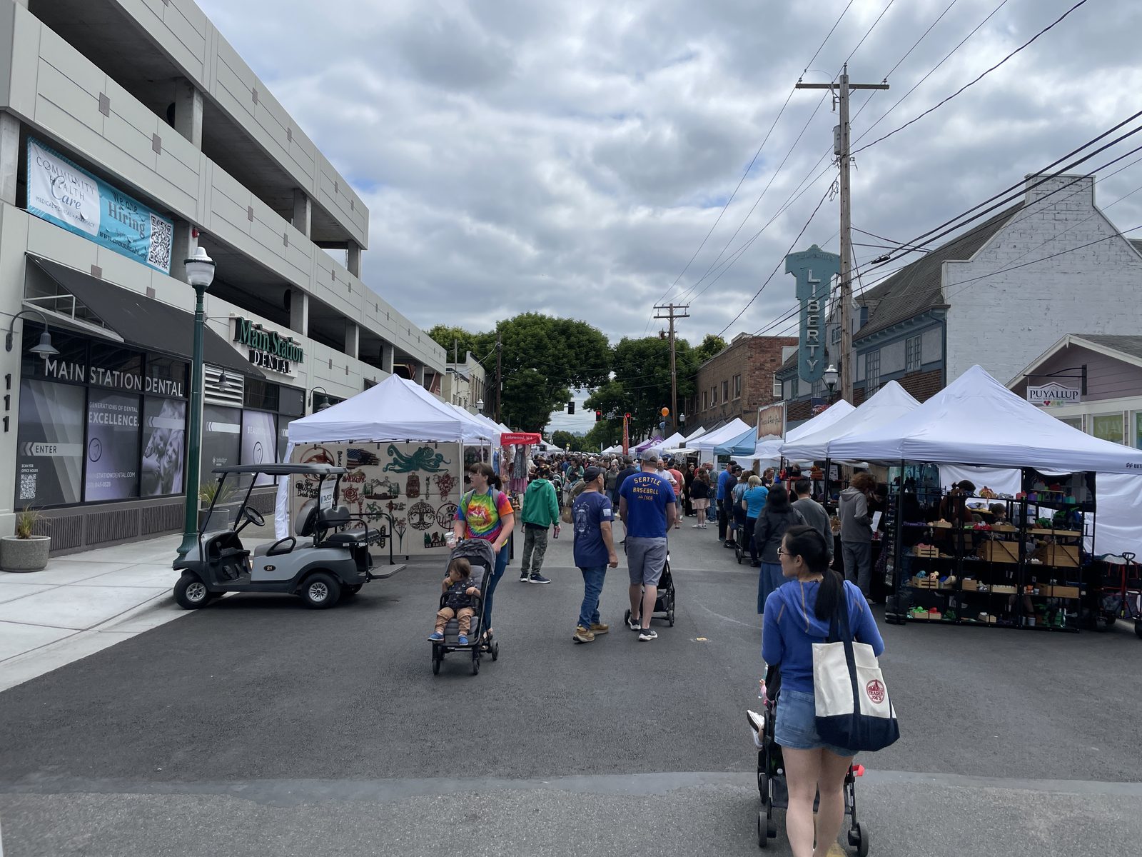 Meeker Days Festival on downtown Puyallup's main street: vendor tents, families with strollers, and the Liberty Theater sign
