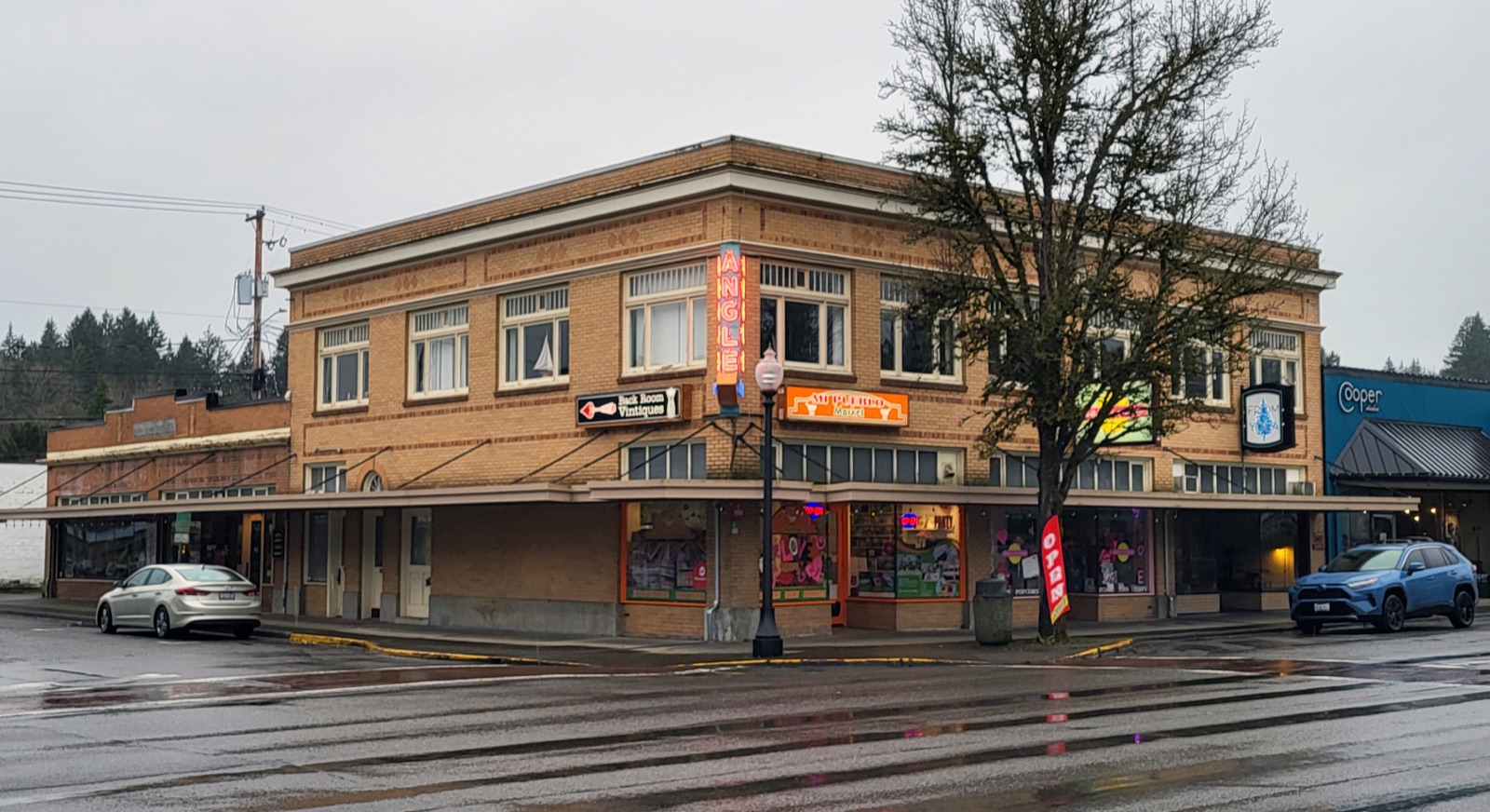 Brick storefronts and covered sidewalks at the Angle Building in downtown Shelton on a rainy day