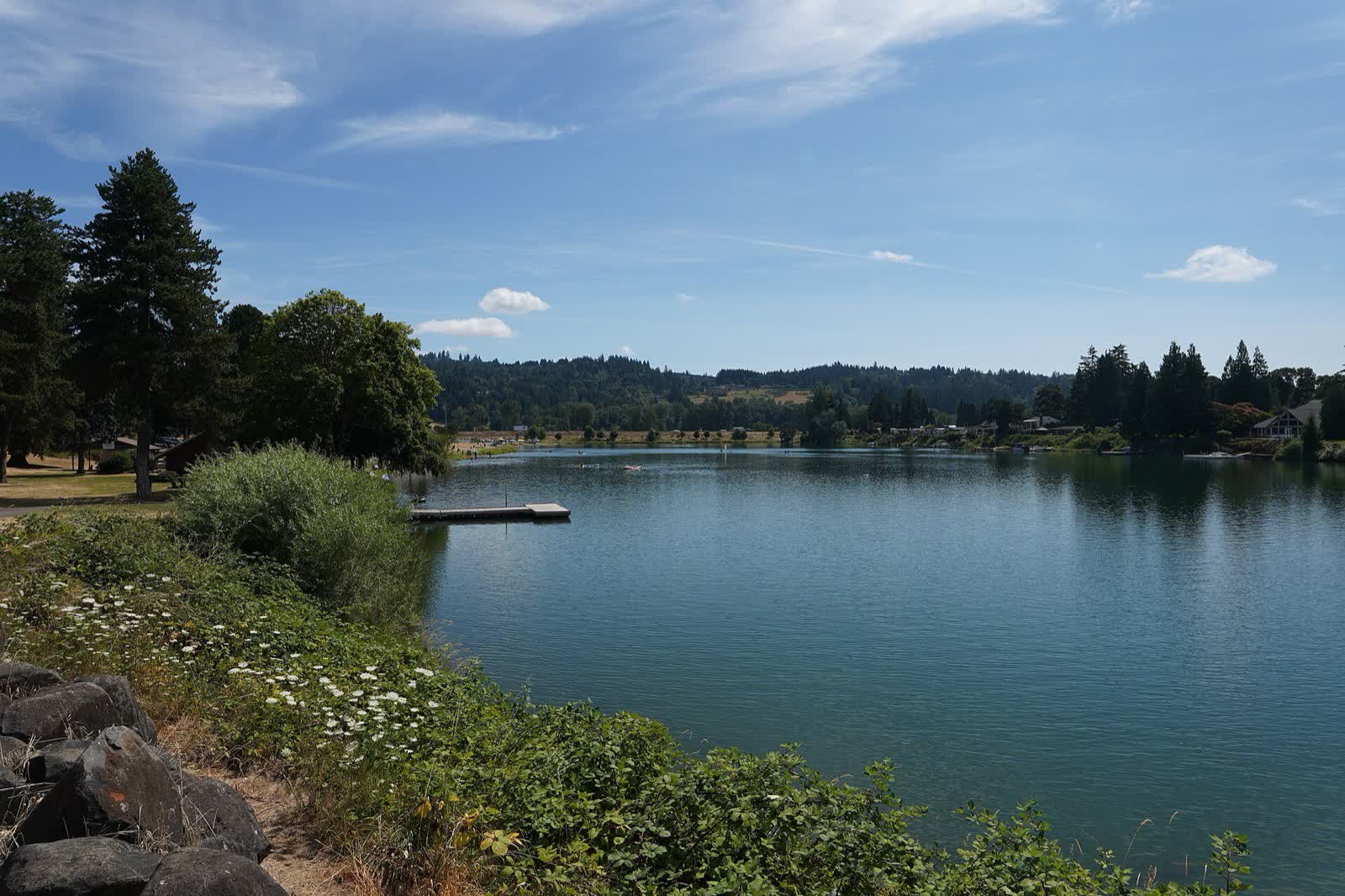 Horseshoe Lake and its swimming area in Woodland, Washington, with forested hills behind